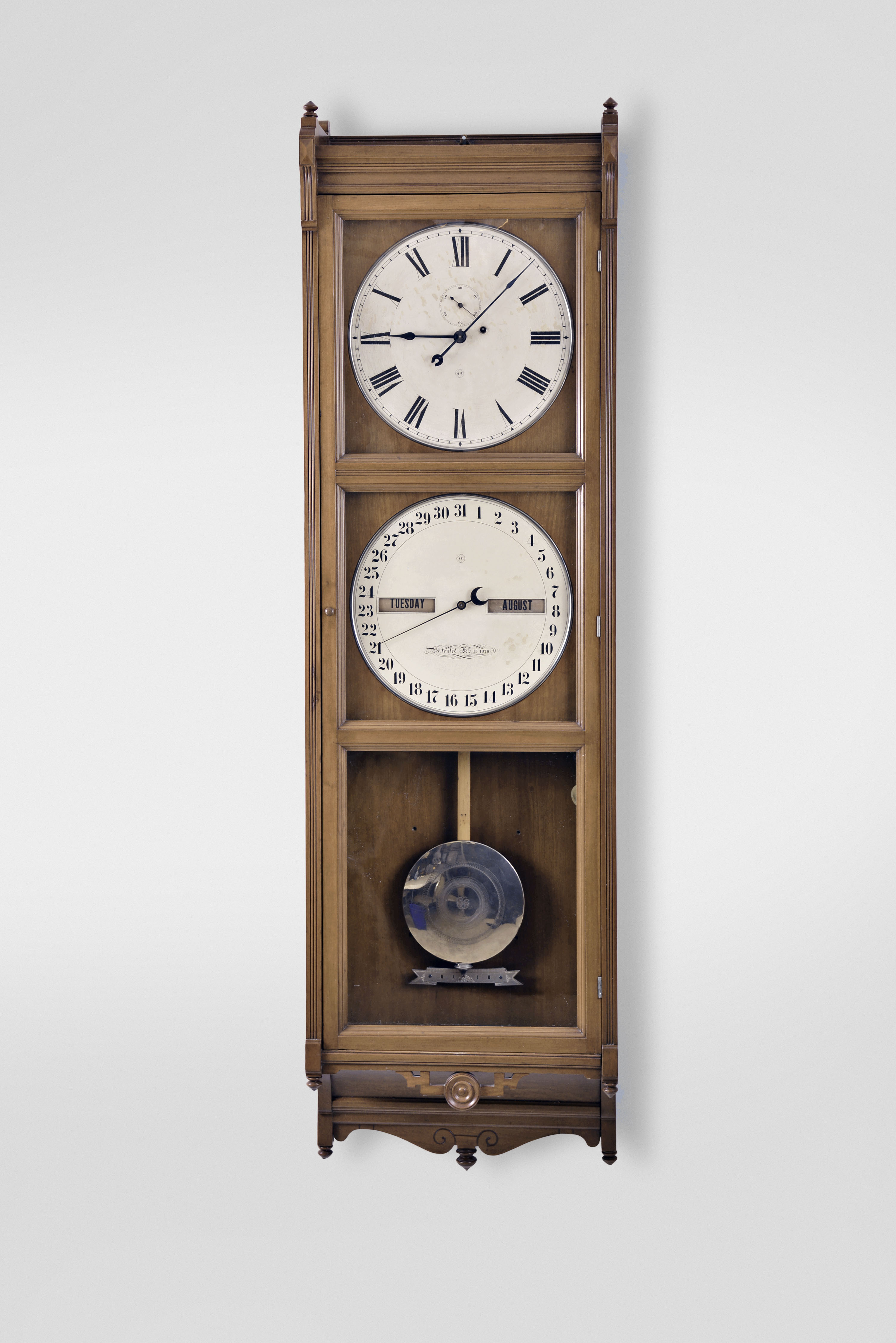 Seth Thomas Clock Co., Thomaston, Conn., "Office Calendar No. 9" wall clock, 8 day, time and perpetual calendar, weight driven movement beating seconds in a cherry case with painted metal dials and seconds bit. — Antique Clocks Price Guide
