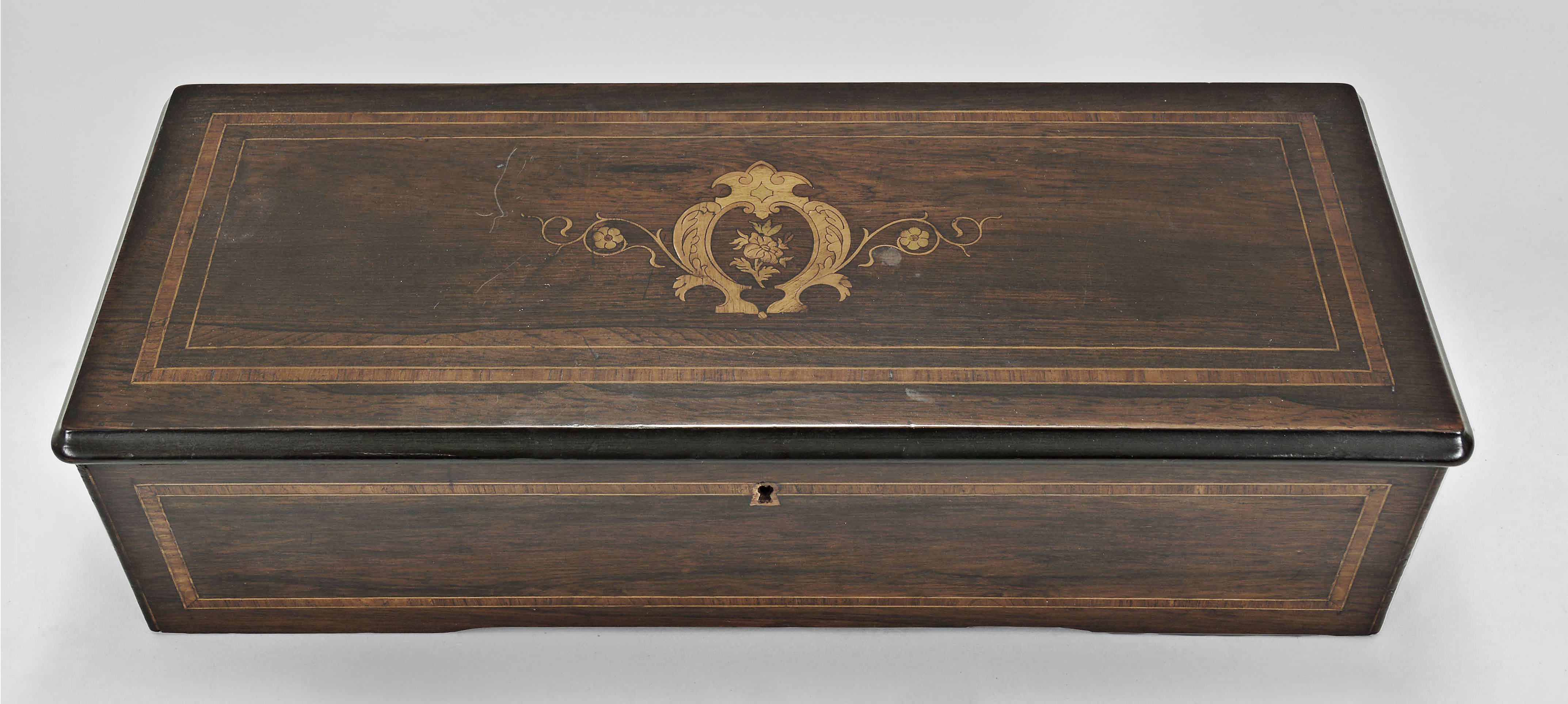 Switzerland, music box, 8 tunes playing with a 13 inch cylinder on a one piece comb having 92 teeth in a hardwood case with inlay on the sides and front, the top marquetry with floral motif, original tune card mounted inside the lid listing airs — Antique Clocks Price Guide
