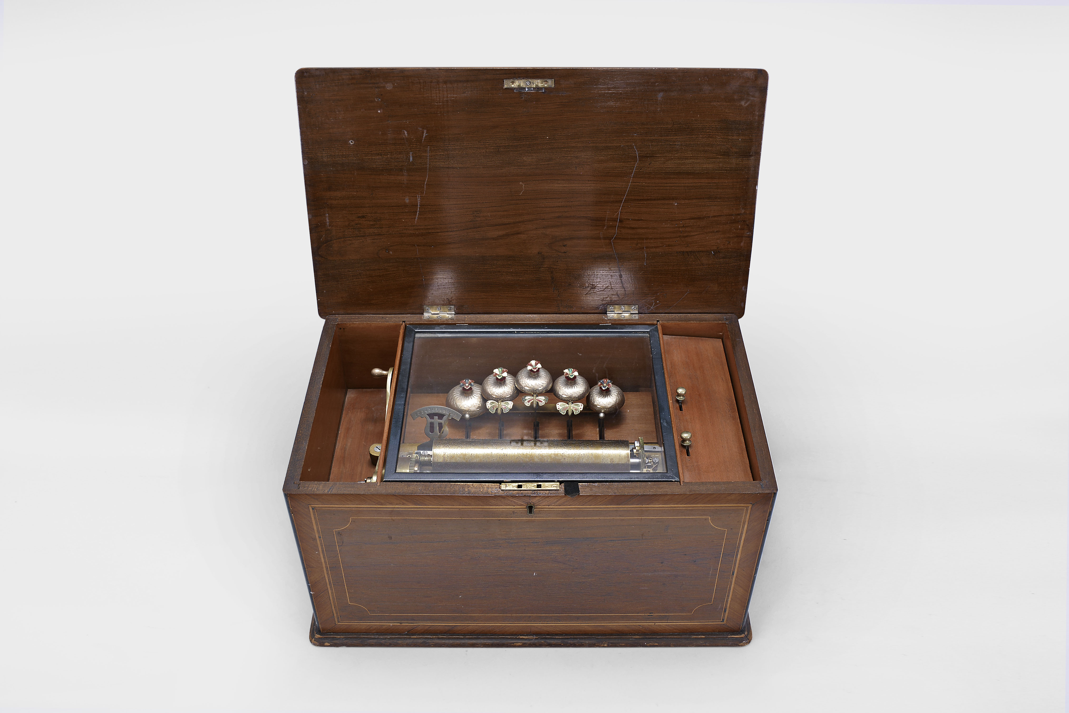 Switzerland, music box, playing 12 tunes with a 9.25 inch cylinder playing on a one piece comb with 44 teeth and five tuned bells, all mounted in a rosewood veneered box with string inlay on the front and top — Antique Clocks Price Guide