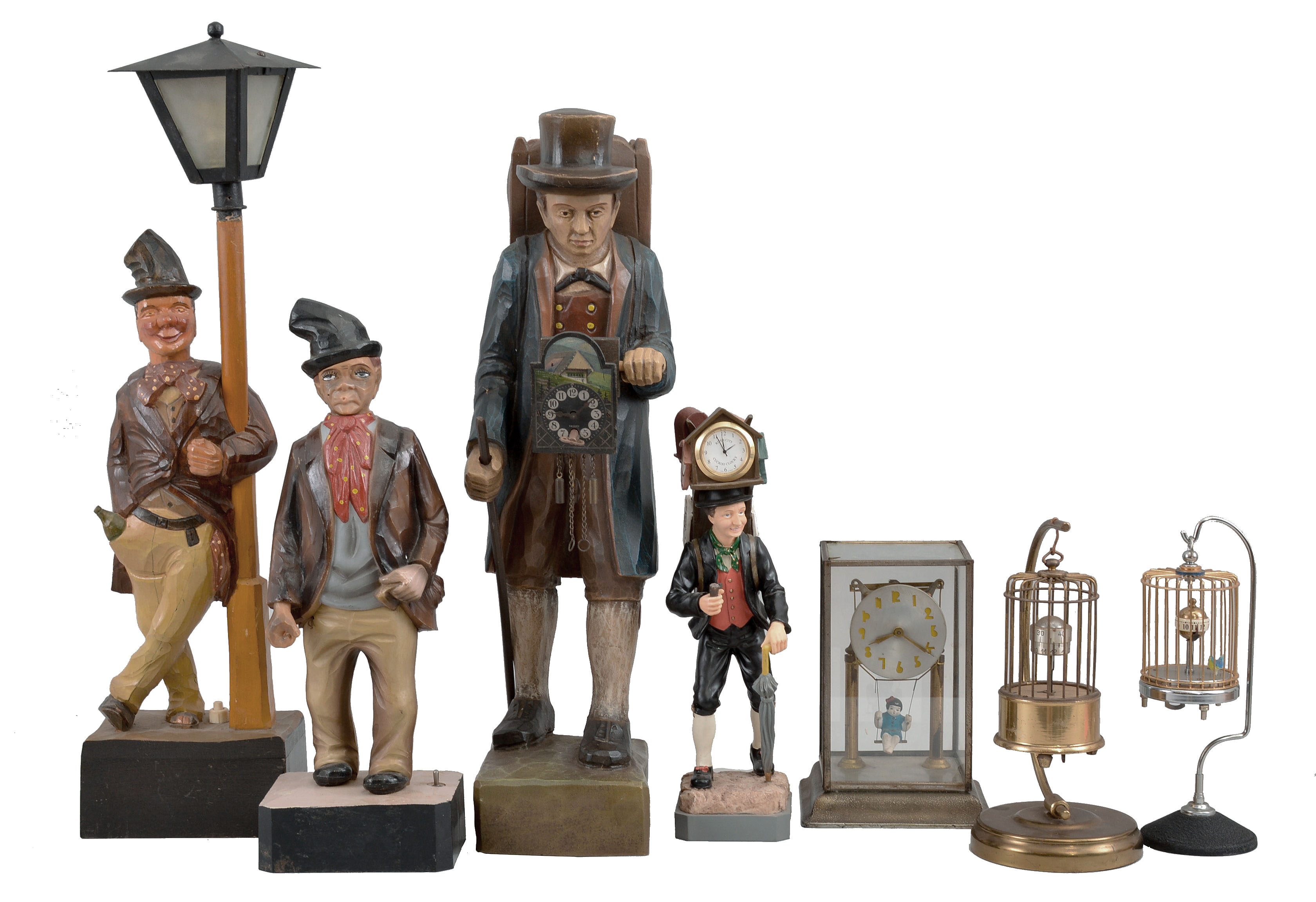 Novelties- 7 (Seven): lot includes: carved figure leaning on a lamp post which holds a small incandescent bulb; plastic battery-operated whistler figure; small clock peddler figure with quartz watch movement; large cast clock peddler figure with German novelty clock movement; Japanese swinging doll clock under glass; German made birdcage clock; Japanese made birdcage clock. — Antique Clocks Price Guide
