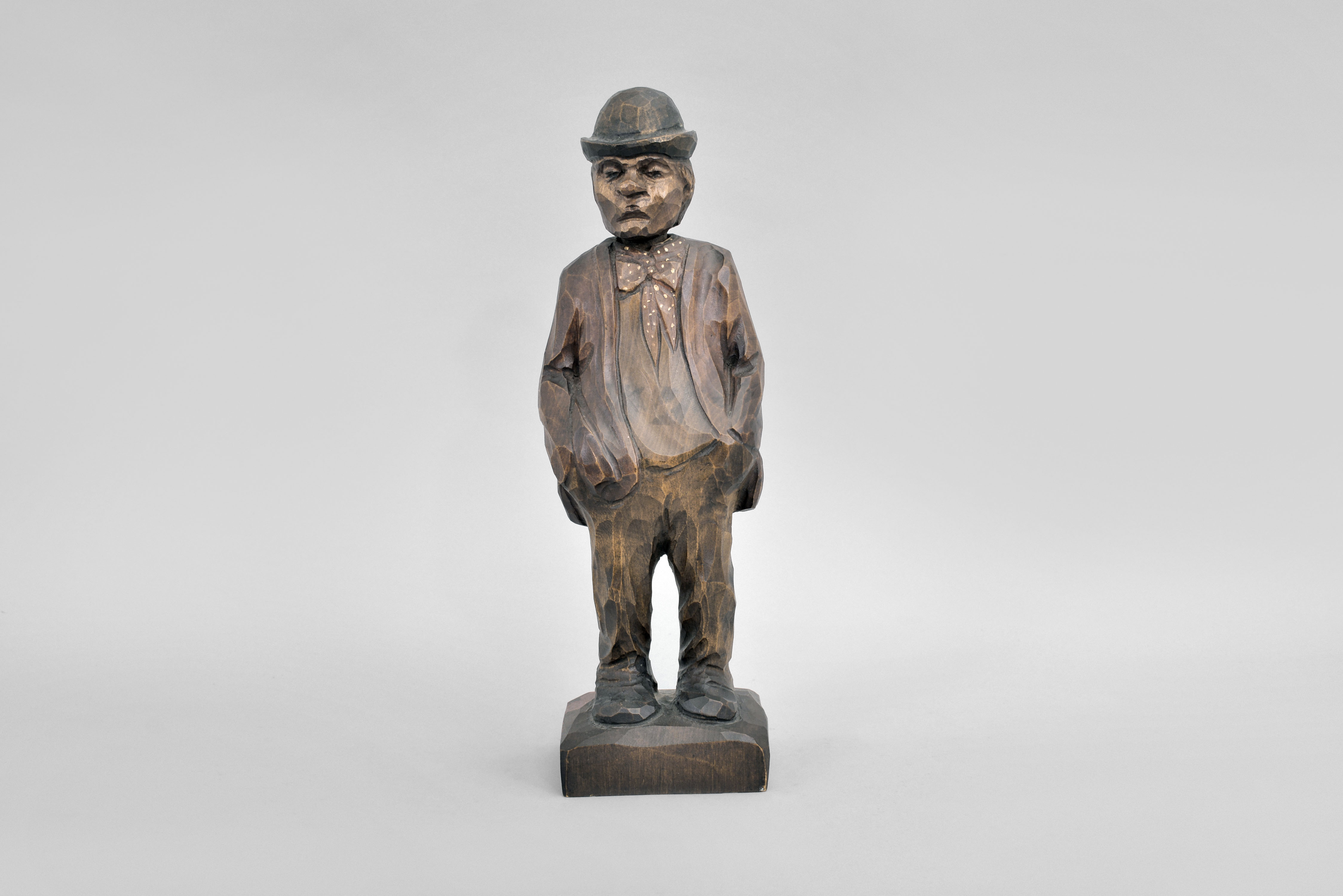 Karl Griesbaum, Triberg, Germany, whistling gentleman, spring driven brass movement powering bellows, slide whistle, and turning head motion, enclosed in hand carved wooden figure depicting a man wearing an bowler hat and bow tie with his hands in his pockets as he whistles a tune. — Antique Clocks Price Guide
