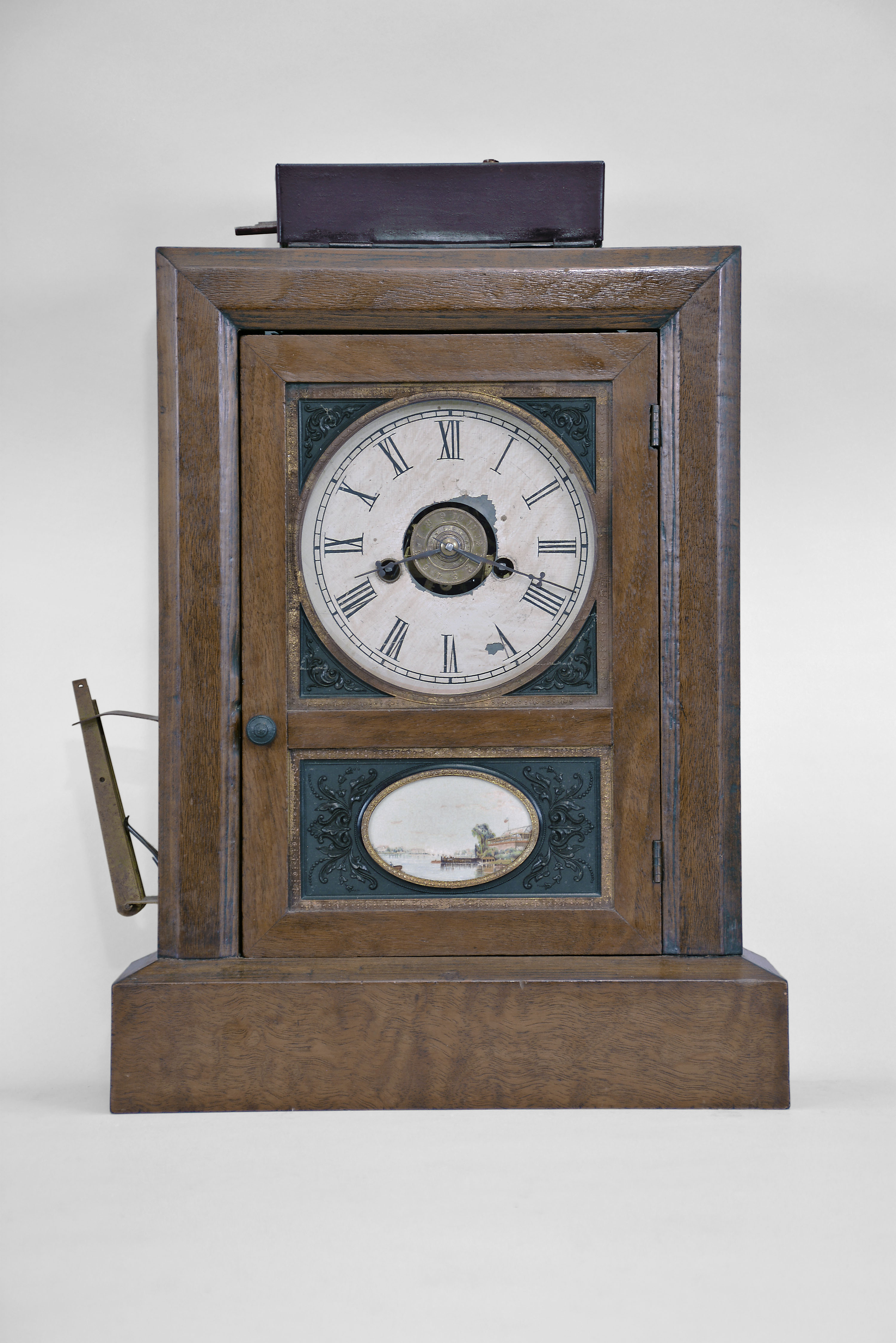 Jerome & Co., New Haven, Conn., cottage clock, 30-hour, time and strike with lamp-lighting burglar alarm, spring driven movement in a mahogany veneered case with decorative thermoplastic inserts in upper and lower parts of door, painted metal dial, and steel hands. — Antique Clocks Price Guide