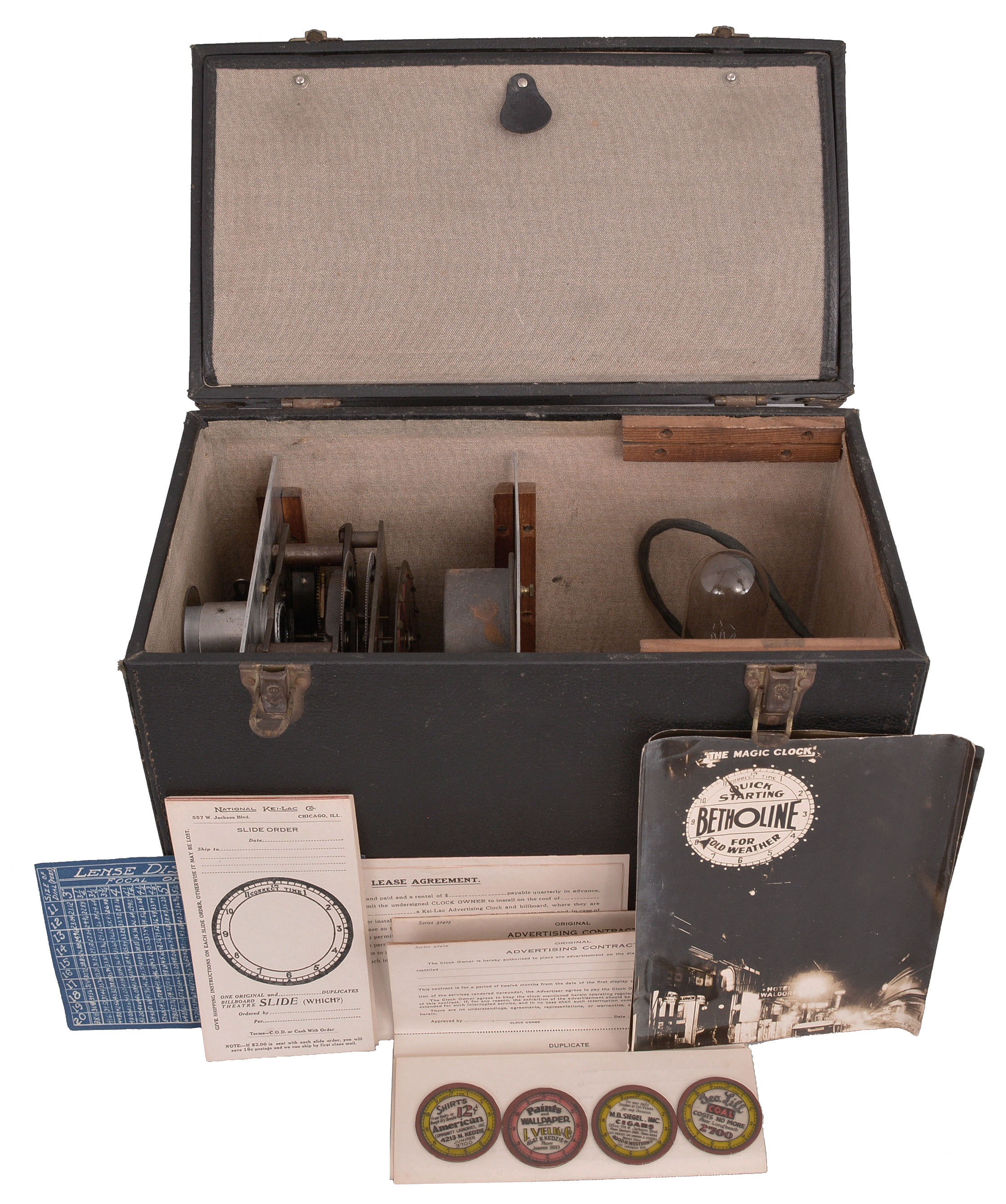 National Kei-Lac Co., Chicago, Illinois, "Kei-Lac Advertising Clock", time and slide projector, one spring driven balance wheel movement tells the time and another spring driven motor advances a circular panel holding 12 glass advertising slides, all within a carrying case with integrated light bulb and original documents. — Antique Clocks Price Guide