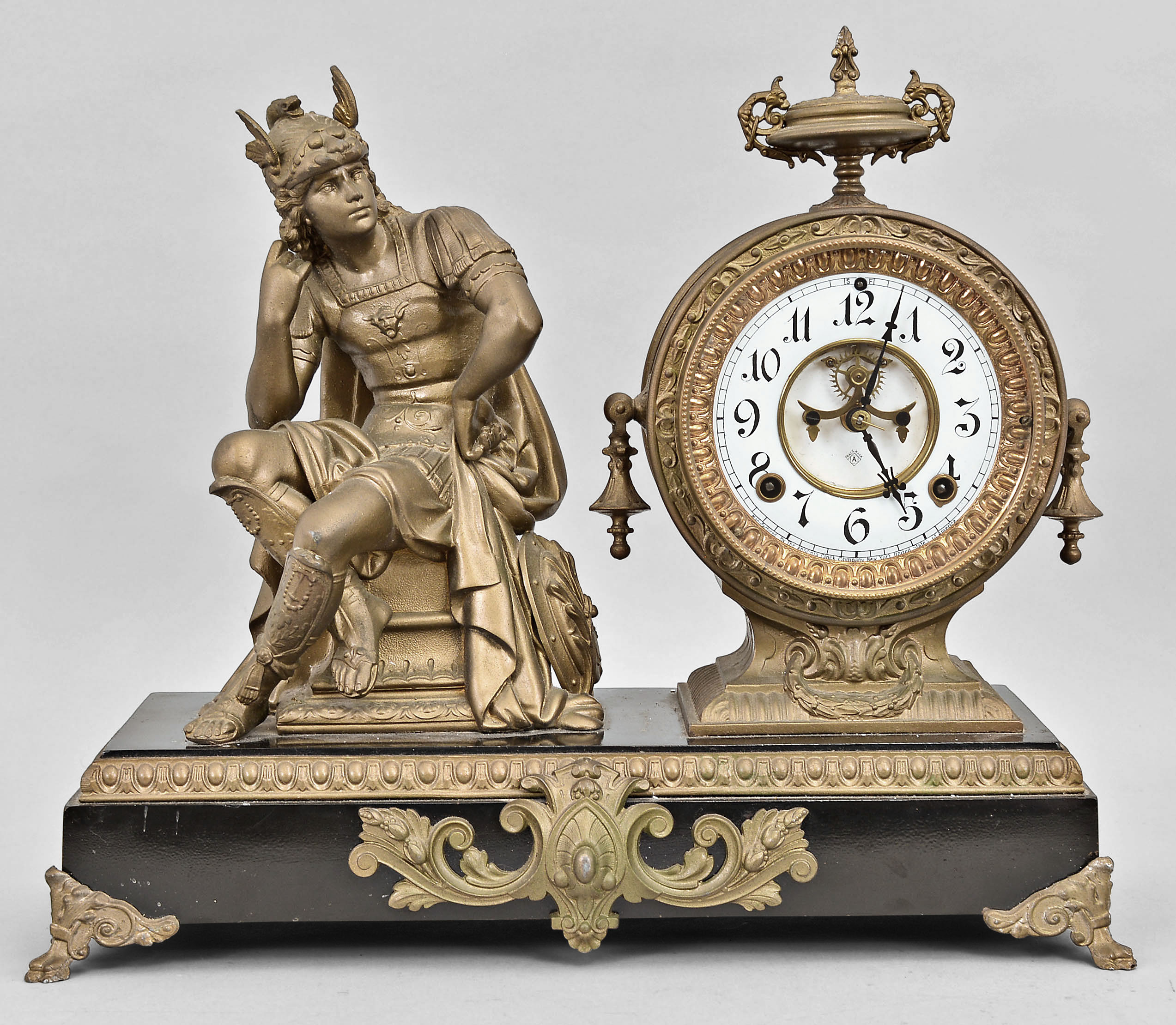 Ansonia Clock Co., New York, "Mercury" mantel clock, 8 day, time and strike, spring driven movement with visible Brocot escapement in a figural case featuring the Roman god Mercury, two-piece white enamel dial and blued steel hands. — Antique Clocks Price Guide