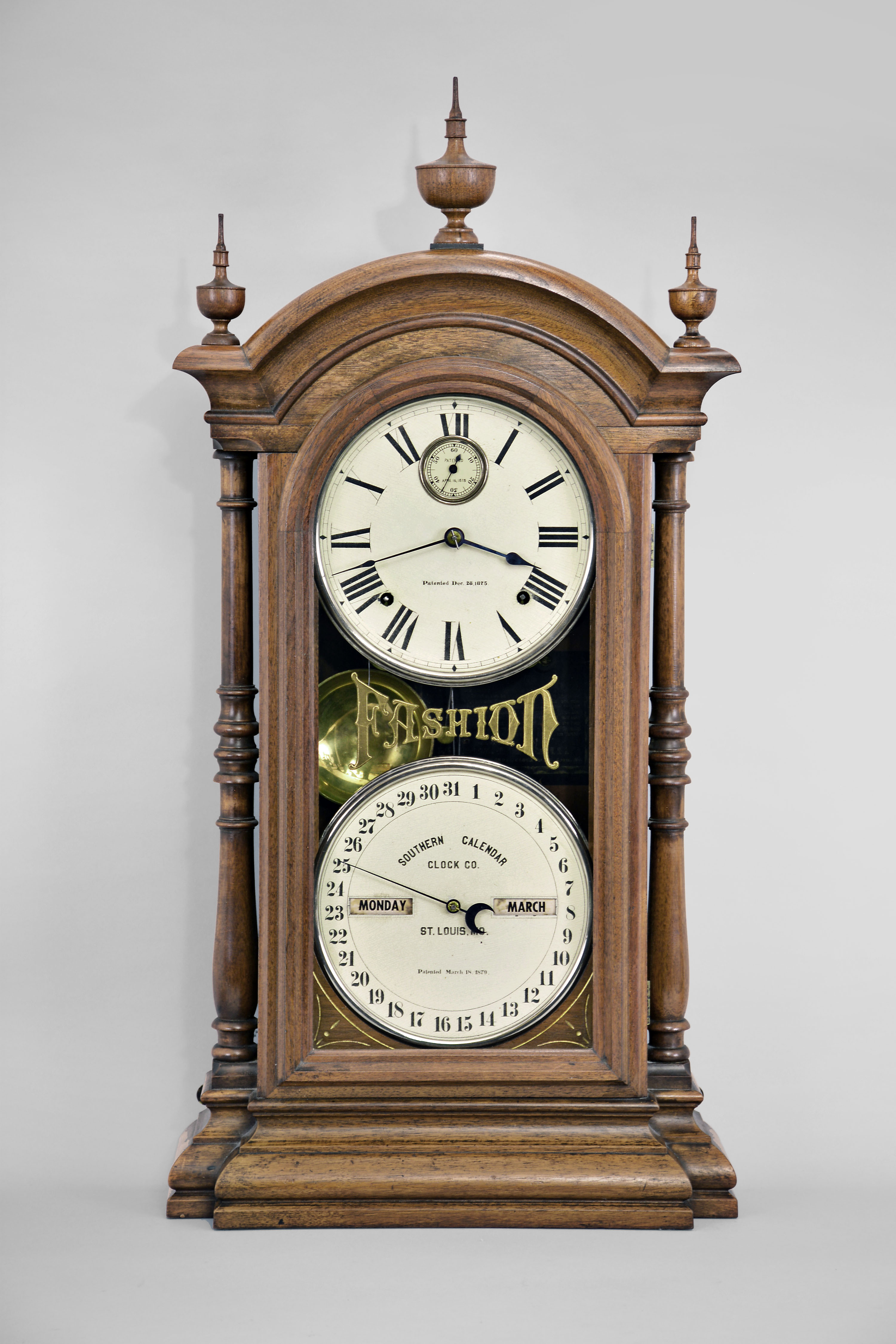 Southern Calendar Clock Co., St. Louis, MO., "Fashion No. 4" double dial shelf clock with a Seth Thomas spring driven, 8 day, time and strike movement and a R. T. Andrews patented perpetual calendar mechanism in a walnut case with painted metal dials — Antique Clocks Price Guide