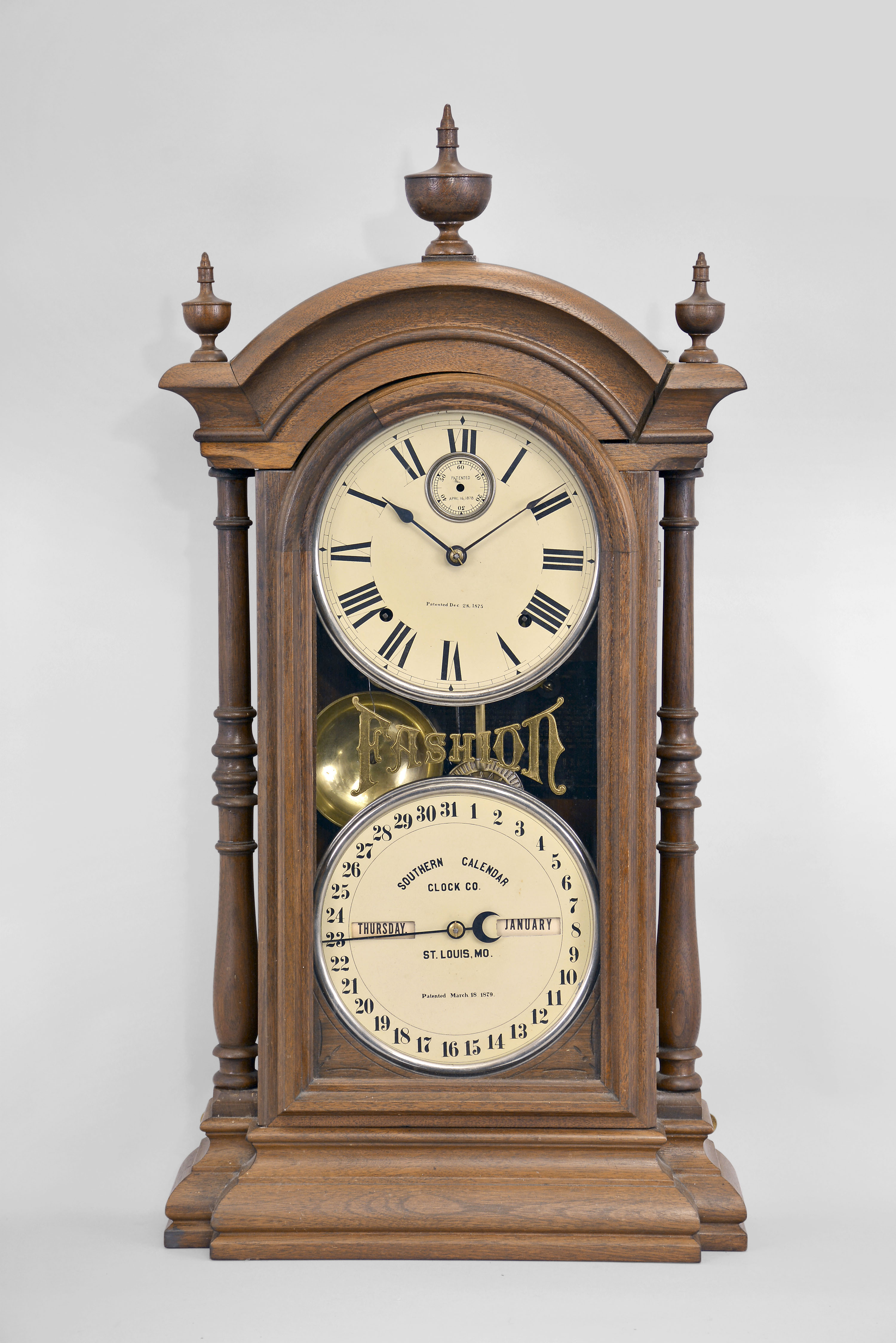 Southern Calendar Clock Co., St. Louis, MO., "Fashion No. 4" double dial shelf clock with a Seth Thomas spring driven, 8 day, time and strike movement and a R. T. Andrews patented perpetual calendar mechanism in a walnut case with painted metal dials — Antique Clocks Price Guide