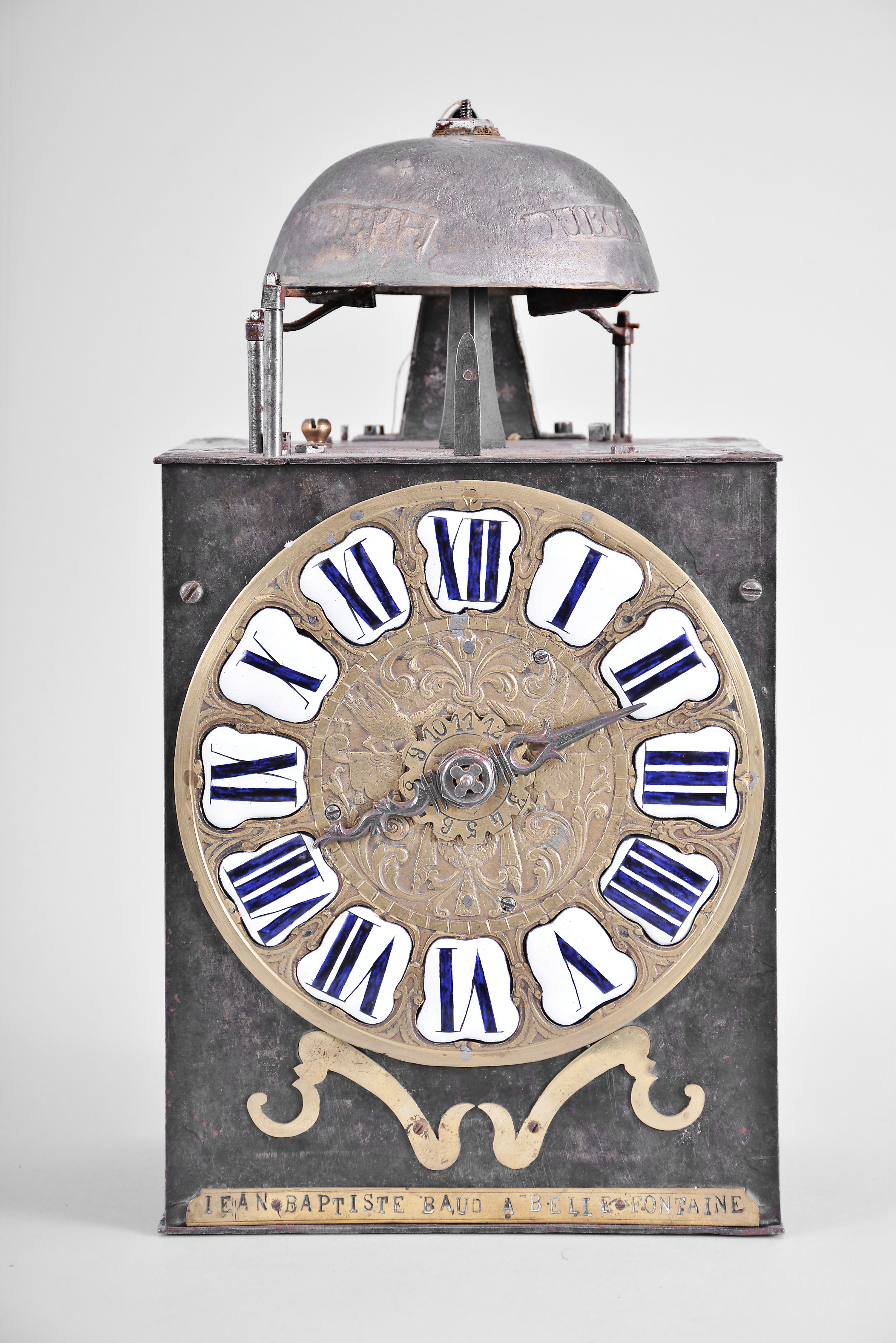 Jean Baptiste Baud, Bellefontaine, France, Comtoise clock, 8 day, time and strike with alarm, weight driven movement with verge escapement, thread suspension with rear-hanging pendulum in a iron post and plate frame, cast brass dial with birds, valances, and inset enamel cartouche numerals, brass alarm ring with Arabic numerals, single pierced iron hand, pivoted brass winding arbor shutters, and lower brass plaque signed "JEAN BAPTISTE BAUD A BELLE FONTAINE ". — Antique Clocks Price Guide