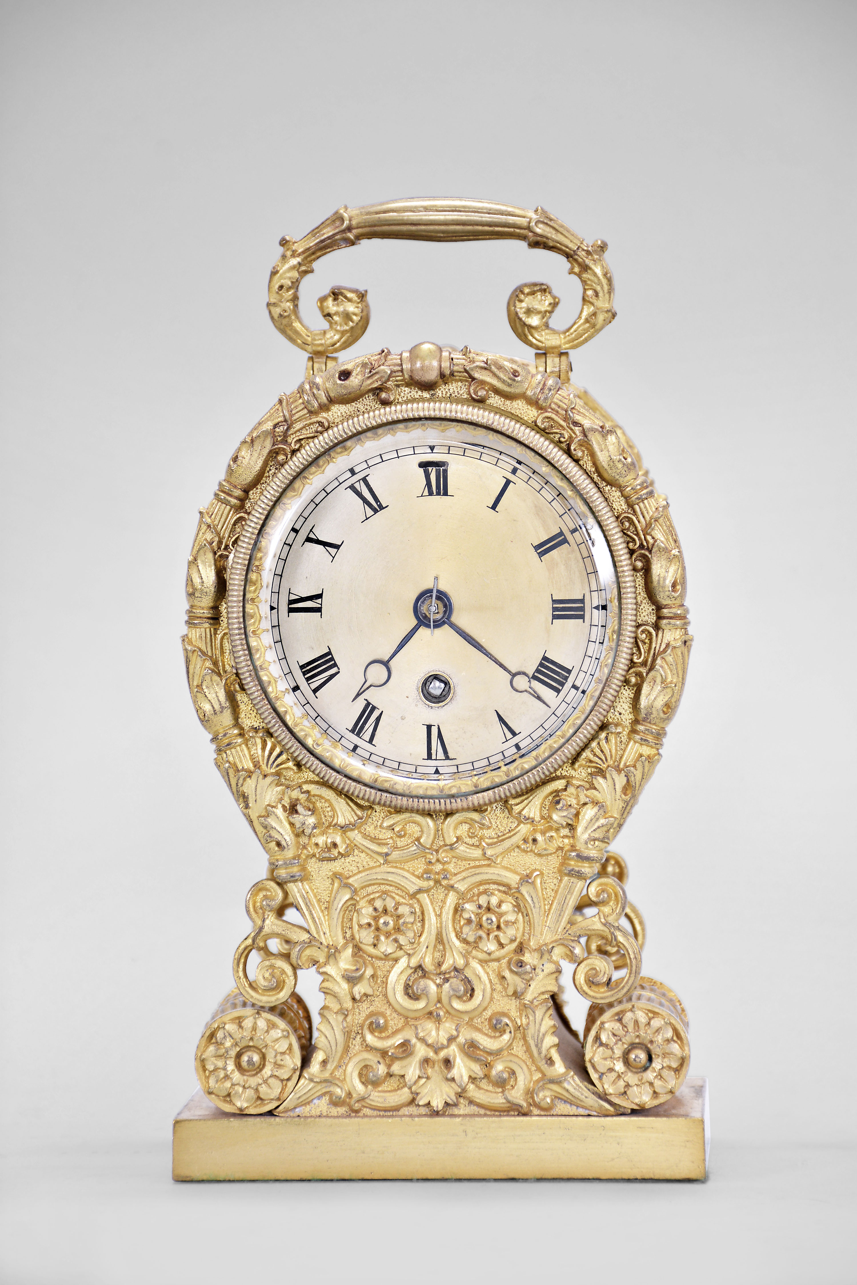 Boston Clock Co., Boston, Mass., carriage clock, 8 day, time only, spring driven movement with jeweled lever escapement in a cast gilt case replete with Grecian ornament reminiscent of French clocks from the 1830s, the movement is enclosed in a glass drum, silvered dial with Roman numerals, fine Breguet variant hands in blued steel. — Antique Clocks Price Guide