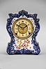 Clocks- 2 (Two) (1) William L. Gilbert Clock Co., Winsted, Conn., "No. 414", 8 day, time and strike spring brass movement porcelain mantel clock; (2) Ansonia Clock Co., New York, "Cabinet No. 51" mantel clock, 8 day, time and strike, spring driven movement in an oak case, brass dial with silvered chapter ring and cast spandrels, c1914.