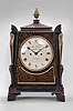 John Palmer, London, bracket clock, 8 day, time and strike, spring driven fusee movement in an Egyptian Revival case made of mahogany with brass inlay and applied brass figures on the corners, the top with anthemion corners, gadrooned plinth supporting a brass finial, painted metal dial signed as above, blued steel spade variant hands.