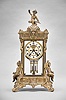 Ansonia Clock Co., New York, "Peerless" crystal regulator, 8 day, time and strike, spring driven movement with visible Brocot escapement in an ornate gilt metal case with two child figures on each side and Cupid with his bow on top, two piece enamel dial with blued steel hands and double-vial pendulum.