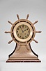 Chelsea Clock Co., Boston, Mass., "Mariner" shelf clock with six inch dial, polished brass case in form of yacht's wheel engraved "PRESENTED TO CAPT. D.M. COCHRAN BY THE Masters of the Goodrich Line Oct. 4 1906" mounted on mahogany stand, signed Arabic numeral silvered special dial with applied numerals also marked "Ships Bell", blued steel hands, 8 day, time and strike movement with lever escapement, serial #15227 including Chelsea marked key