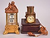 Clocks- 2 (Two): (1) Lenzkirch AG, Lenzkirch, Germany, digital flip card clock, spring driven balance wheel movement in a glazed case with dolphin-form feet, surmounted by a child wresting a sea creature, c1900; (2) Projection clock, 30 hour, time and light projection, spring driven balance wheel movement in a brass case with battery compartment in the base and corded push-button switch, c1920.