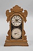 Waterbury Clock Co., Waterbury, Conn., "Oswego" double dial gingerbread style calendar clock, 8 day, time and strike with alarm and perpetual calendar, spring driven movement in an oak case.
