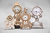 Clocks- 4 (Four): (1) Waterbury Clock Co., Waterbury, Conn., mantel clock, 8 day, time and strike, spring driven movement in a cast metal case featuring a putto holding the clock aloft, cream porcelain dial, 1915; (2) Austria, mantel clock, 2 day, time and strike, spring driven movement in a silver plate-over-copper case with white enamel dial, c1840; (3) Waterbury Clock Co., Waterbury, Conn., novelty clock, 30 hour, time only movement with thread suspension in a cast metal case with painted ceramic panel and topped by putto figure, c1905; (4) Germany, novelty clock, 30 hour, time only, spring driven movement in a porcelain case with putti figures, c1920.