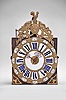 France, bronze-front Comtoise clock, 8 day, time and strike with alarm, weight driven movement, verge escapement with thread suspension and rear-hanging pendulum in an iron post and plate frame, cast brass dial with inset white enamel cartouches with blue Roman numerals for the hours and black Arabic numerals for the minutes, brass alarm ring with Arabic numerals, two pierced steel hands, applied brass spandrels below the dial, and topped with a cast fronton featuring a forward facing Gallic rooster over a medallion with three fleur de lis.