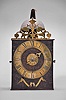France, Comtoise clock, 8 day, time and strike with alarm, weight driven movement with verge escapement, thread suspension with rear-hanging pendulum in a iron post and plate frame, brass chapter ring with Roman numerals, brass alarm ring with Arabic numerals, pivoted winding arbor shutters, single pierced brass hand, all surmounted by a pierced brass fronton.