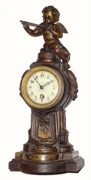 C.1910, French, Figural timepiece, surmounted by a winged cherub with a flute in his hands. — Antique Clocks Price Guide