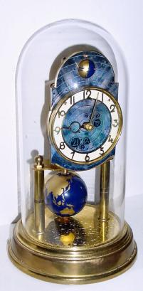 C.1954, German, J. Kaiser, 400-Day clock, World model, with terrestrial globe pendulum and Halifax moon revolving in the arch of the dial. — Antique Clocks Price Guide