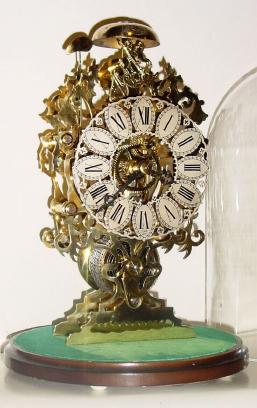 Mid 20th Century, English, Passing Strike Skeleton clock in a delicate scroll & leaf style frame with engraving on the front plate. — Antique Clocks Price Guide