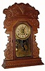 C.1900, E. N. Welch Mfg. Co., 8-day time/strike/alarm oak case gingerbread shelf clock in clean condition with original dial, hands, pendulum and tablet. 