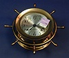 A BRASS CASED SHIPS CLOCK. With wheel decoration, labeled "Helmsman", Seth Thomas.