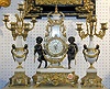 A PARCEL-GILT BRONZE MOUNTED PORCELAIN CLOCK GARNITURE.